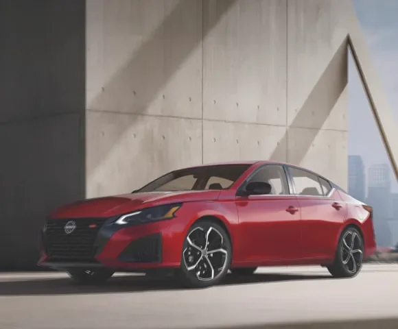 Red 2027 Nissan Altima midsize AWD sedan 3/4 profile view, parked in a well-lit garage at MATZ Nissan in Troy AL
